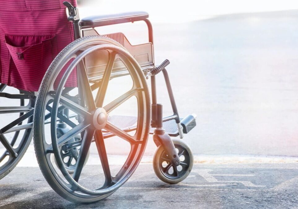 A close up of an empty wheelchair on the sidewalk